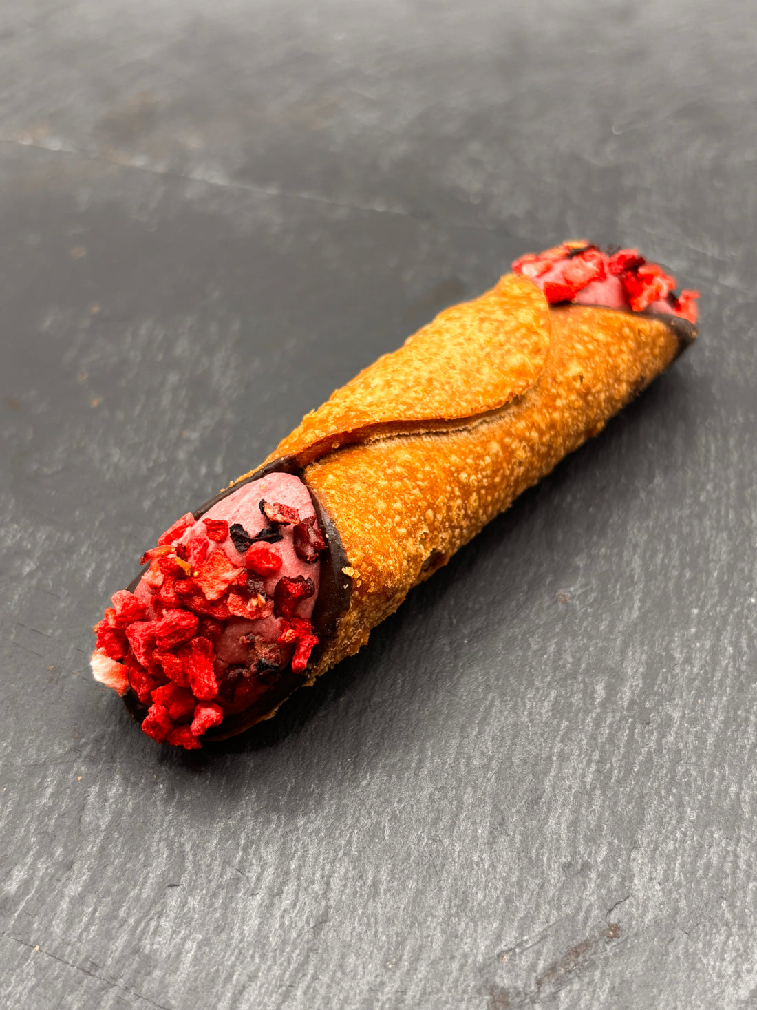 Een heerlijke Cannoli Frutti di Bosco - Bosvruchten, traditioneel Siciliaans gebakje gevuld met romige bosvruchten-vulling, perfect om te genieten bij een bakje koffie.